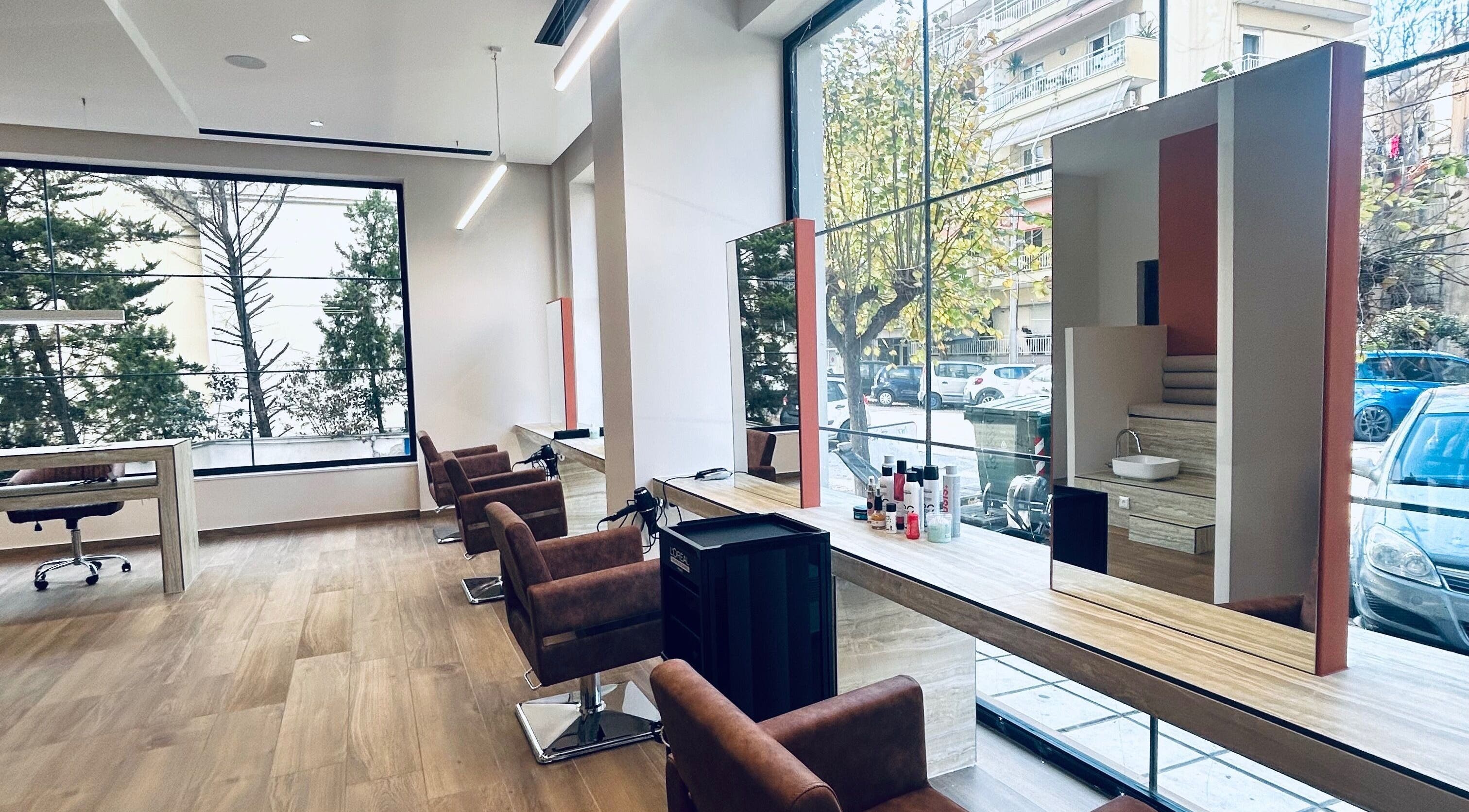 Εσωτερικός χώρος του ELYSIA TOUCH στη Θεσσαλονίκη, GR με καρέκλες κομμωτηρίου δίπλα σε μεγάλα παράθυρα.