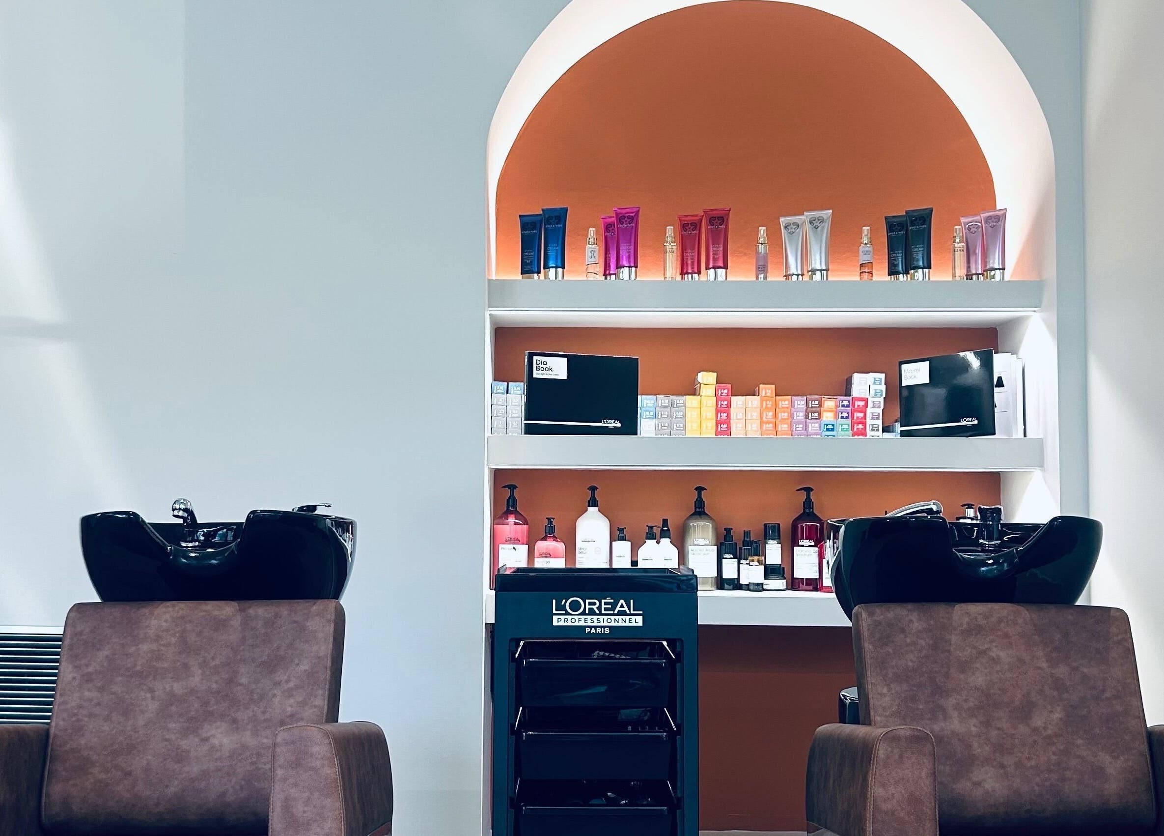 Καρέκλες σαλόνι ELYSIA TOUCH στη Θεσσαλονίκη, GR με προϊόντα ομορφιάς στον τοίχο.