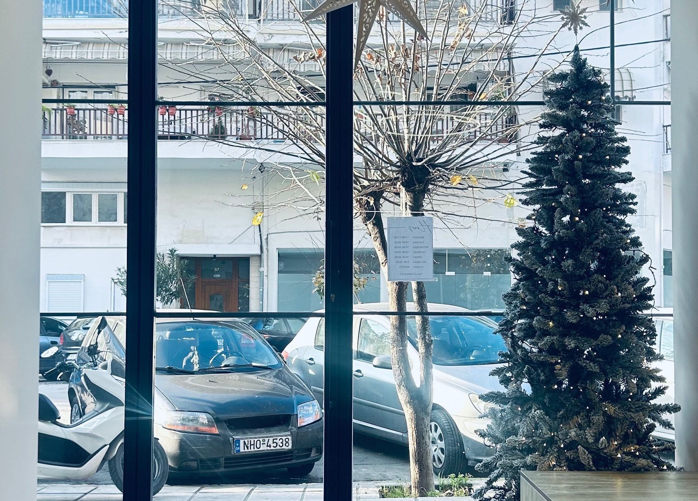 Εορταστική είσοδος στο ELYSIA TOUCH στη Θεσσαλονίκη, GR με χριστουγεννιάτικο δέντρο και θέα στον δρόμο.