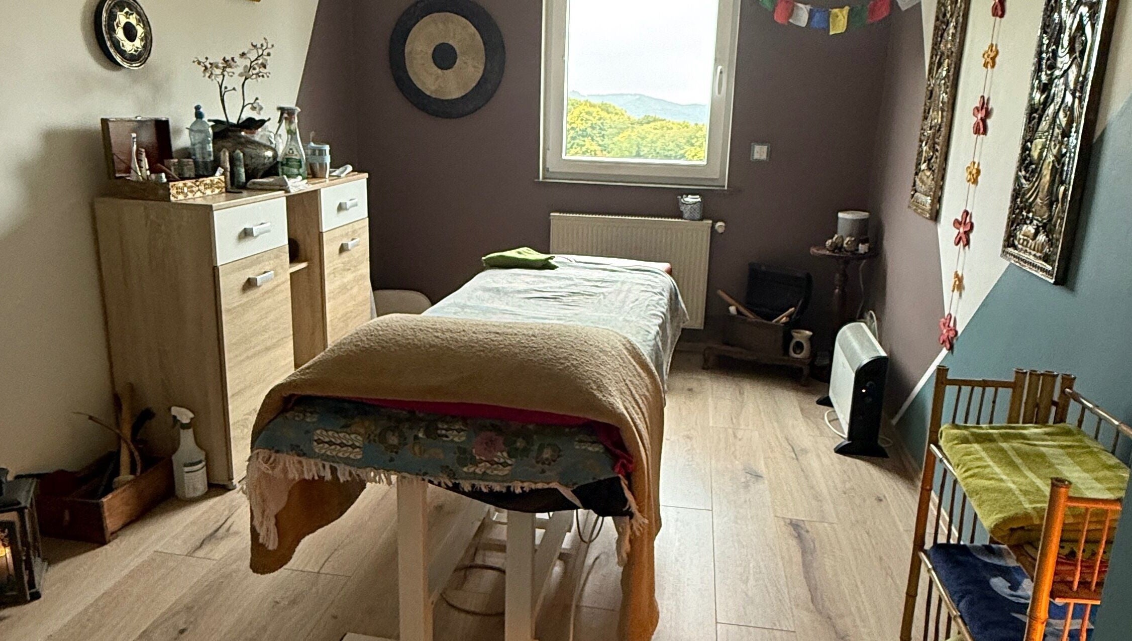 Wohlfühlraum bei MaNa Thaimassage in Hausen, Rheinland-pfalz, DE mit Massagetisch und beruhigender Dekoration.