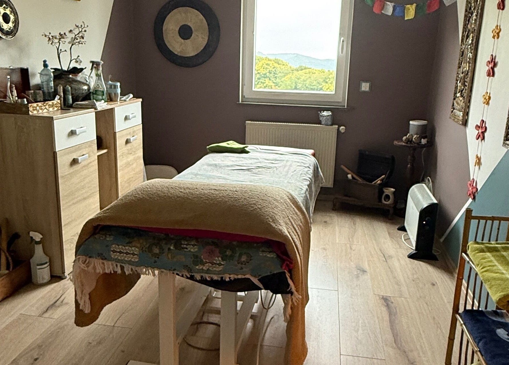Wohlfühlraum bei MaNa Thaimassage in Hausen, Rheinland-pfalz, DE mit Massagetisch und beruhigender Dekoration.