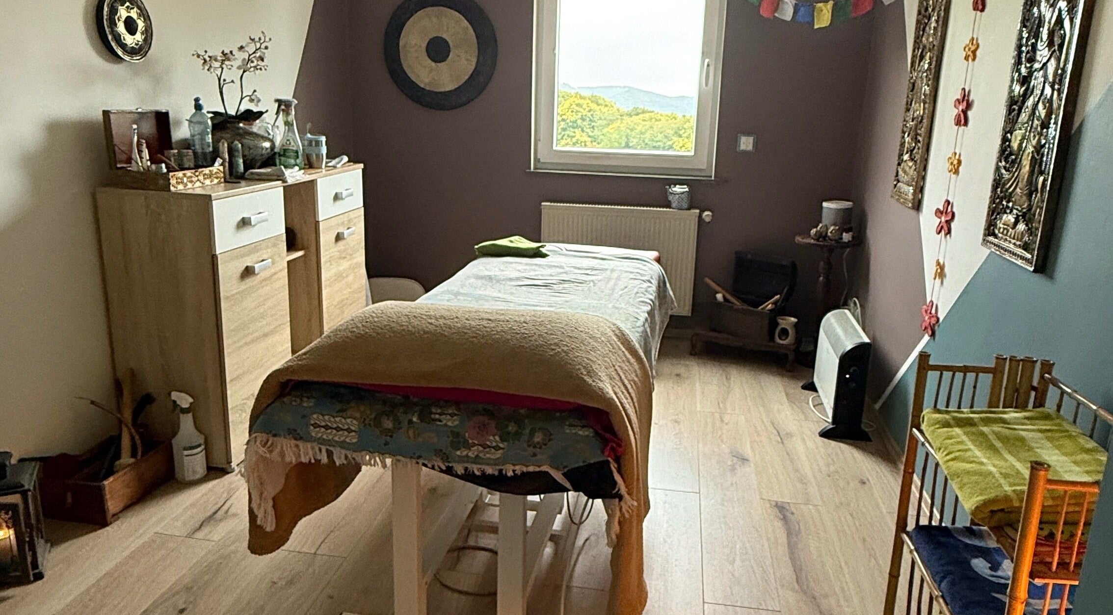 Wohlfühlraum bei MaNa Thaimassage in Hausen, Rheinland-pfalz, DE mit Massagetisch und beruhigender Dekoration.