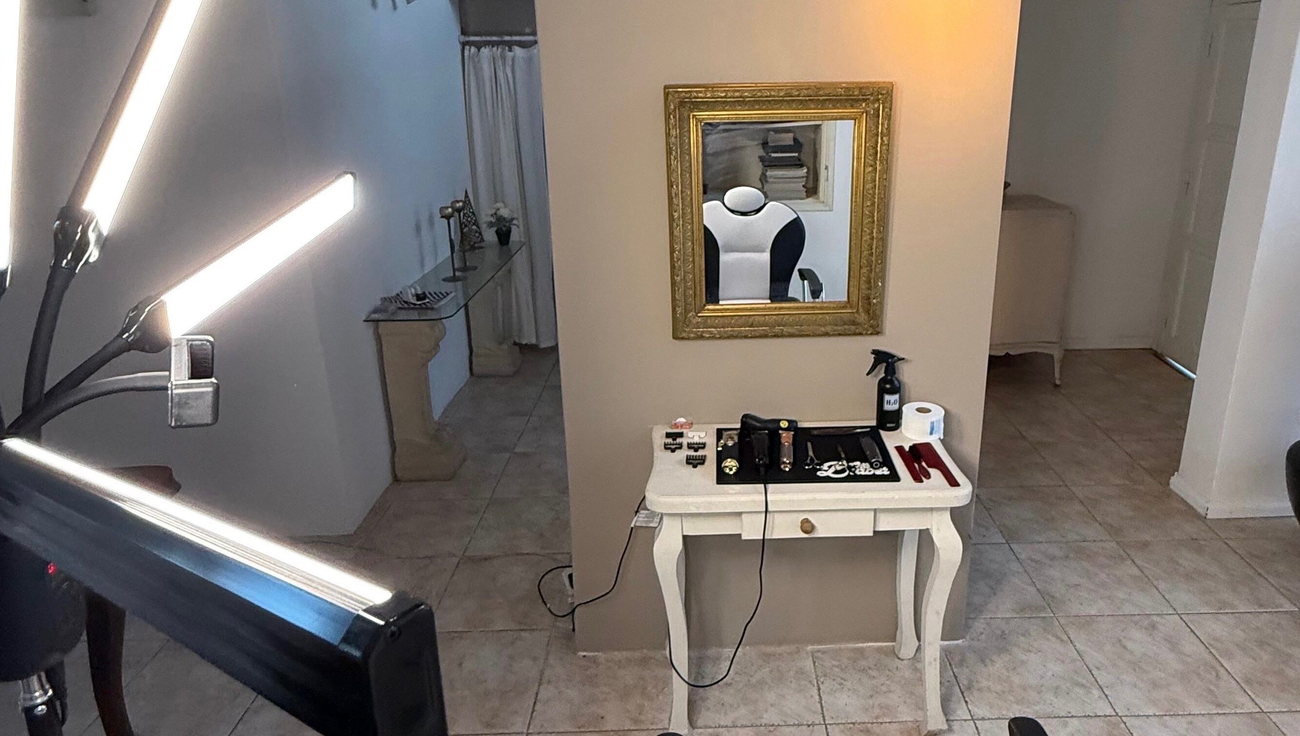 Espacio moderno en Agus barbería, Campana, Provincia De Buenos Aires, AR. Espejo dorado y herramientas estilísticas.