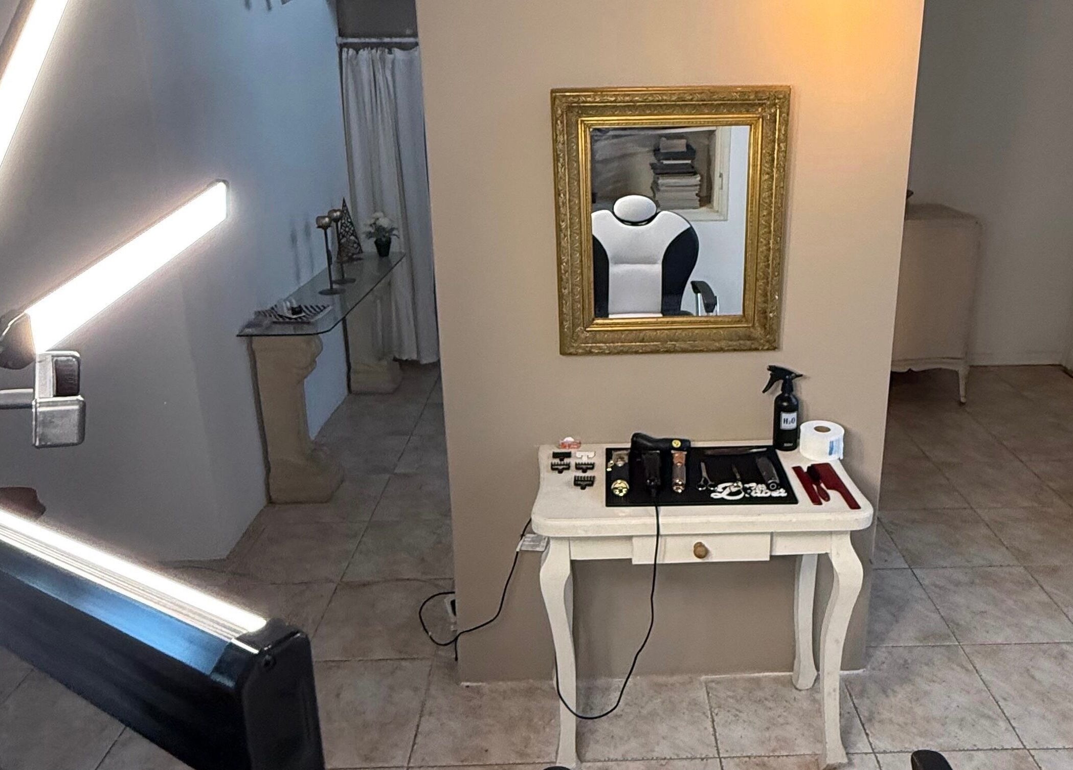 Espacio moderno en Agus barbería, Campana, Provincia De Buenos Aires, AR. Espejo dorado y herramientas estilísticas.