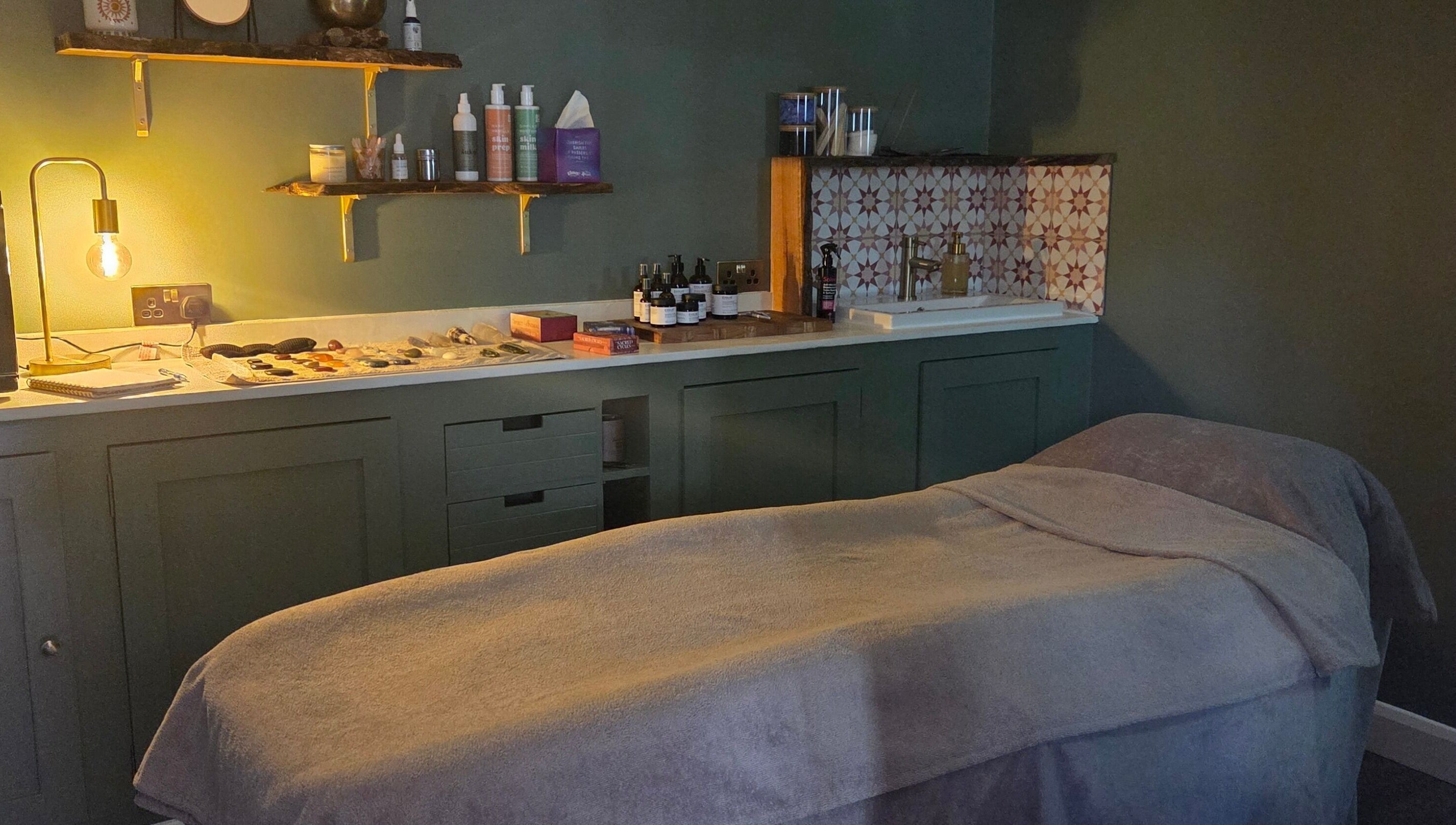 Cozy treatment room at The Blissful Element in Chandler's Ford, England, GB with massage table and ambient lighting.