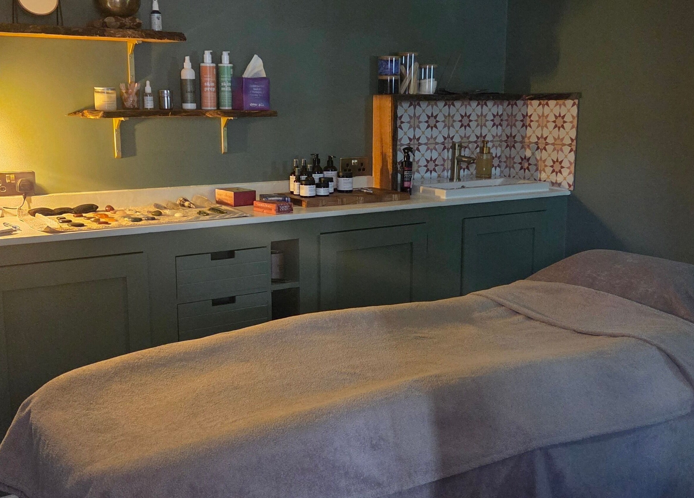 Cozy treatment room at The Blissful Element in Chandler's Ford, England, GB with massage table and ambient lighting.