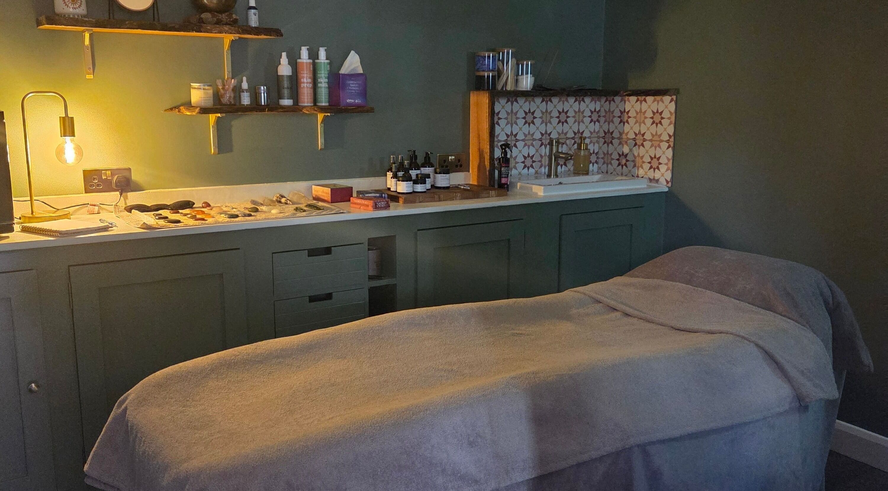 Cozy treatment room at The Blissful Element in Chandler's Ford, England, GB with massage table and ambient lighting.