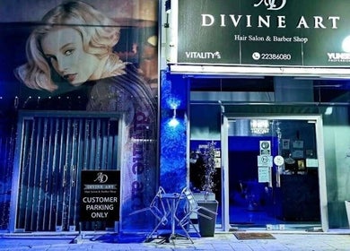 Η είσοδος του Divine Art Hairdressing Salon στη Λακατάμια, Λευκωσία, CY, φωτισμένη το βράδυ.
