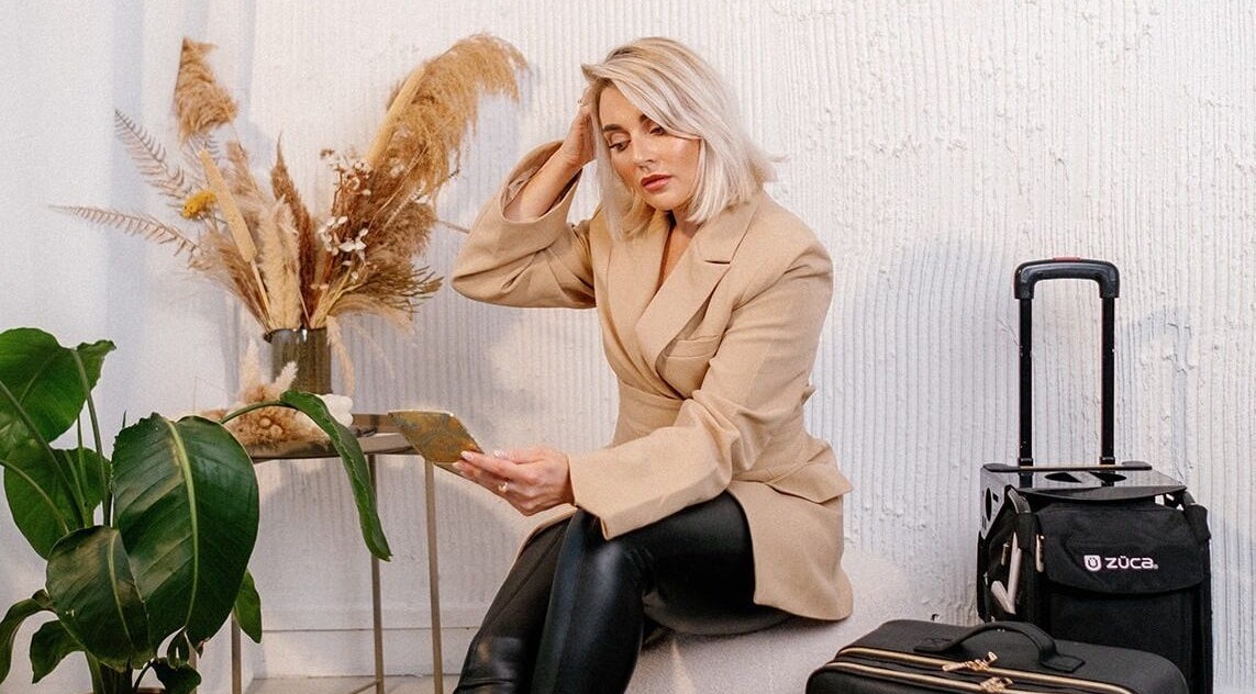 Woman in tan blazer at Celfie Bridal Hair and Makeup, Midsomer Norton, England, ready for beauty services.