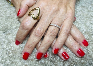 Mains avec vernis rouge à Nailsbyrose, Chalon-sur-saône, Bourgogne-franche-comté, FR, sur un fond texturé.