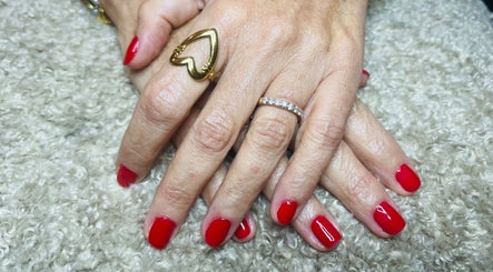 Mains avec vernis rouge à Nailsbyrose, Chalon-sur-saône, Bourgogne-franche-comté, FR, sur un fond texturé.