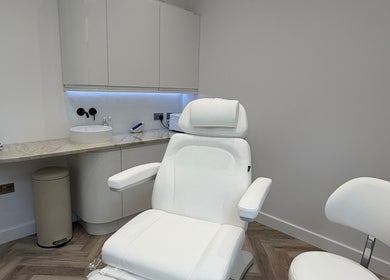Modern treatment room at CUTit, Beckenham, England, GB with white furnishings and marble countertop.