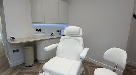 Modern treatment room at CUTit, Beckenham, England, GB with white furnishings and marble countertop.