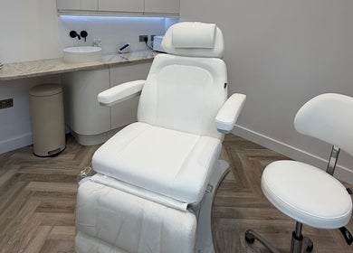 Elegant white treatment chair at CUTit. in Beckenham, England, GB. Modern, inviting, and pristine workspace.