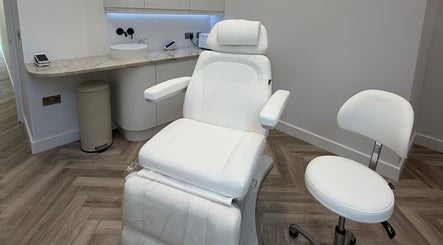 Elegant white treatment chair at CUTit. in Beckenham, England, GB. Modern, inviting, and pristine workspace.