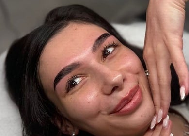 Woman with perfect eyebrows smiling at By Brow Hunnies in Dubai, Dubai, AE.
