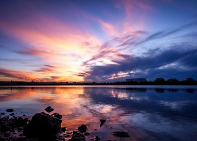 Wunderschöner Sonnenuntergang bei Wax Affairs Wiesbaden, Hessen, DE mit reflektierendem Himmel über Wasser.