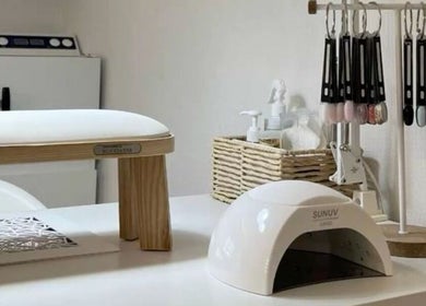 Nail station at Nailed.By.Penny, Boksburg, Gauteng, ZA, showcasing polishes and a UV lamp.