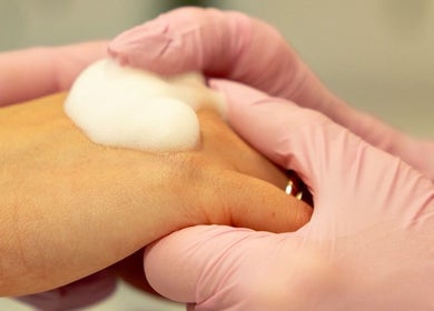 Hand treatment at Kateryna Nails, Birmingham, England, GB, showcasing gentle foam application on a client’s hands.