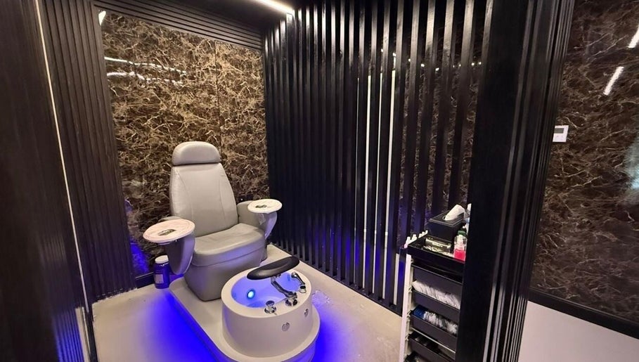 Luxurious pedicure chair at Hair Zone - Al Yasmin, Riyadh, Riyadh Province, SA with sleek black marble walls.