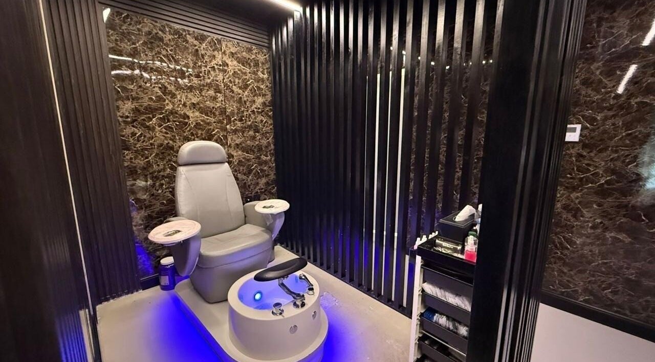 Luxurious pedicure chair at Hair Zone - Al Yasmin, Riyadh, Riyadh Province, SA with sleek black marble walls.
