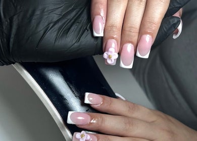 Elegant pink and white nail design with floral accents at T Tips And Toes, St Albans, England, GB.