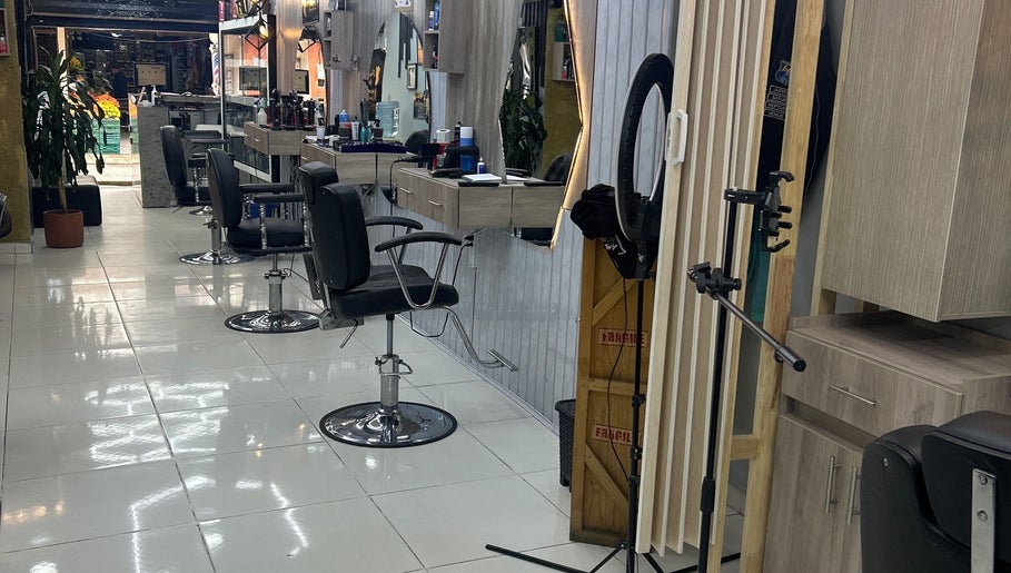 Interior del AMERICAN BARBER SHOP en Marinilla, Antioquia, CO, con modernas sillas de barbería y elegantes espejos.