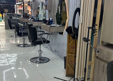 Interior del AMERICAN BARBER SHOP en Marinilla, Antioquia, CO, con modernas sillas de barbería y elegantes espejos.