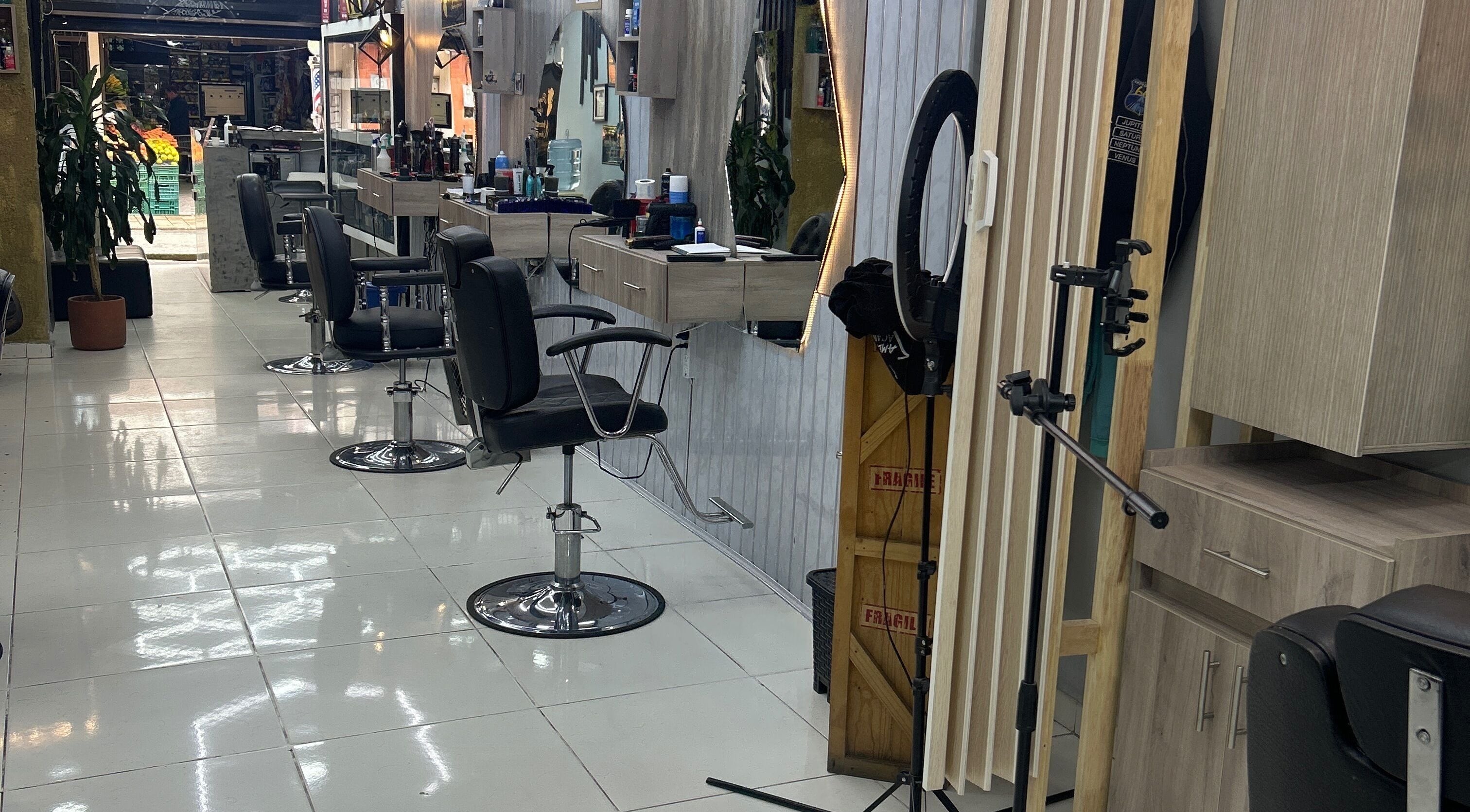 Interior del AMERICAN BARBER SHOP en Marinilla, Antioquia, CO, con modernas sillas de barbería y elegantes espejos.