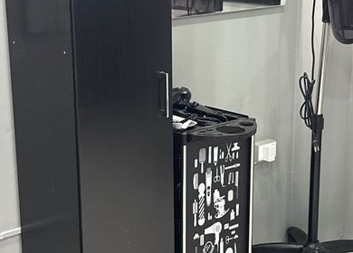 Hair styling station at Kimmi’s Luxe Lounge in San Juan, featuring modern appliances and sleek black design.