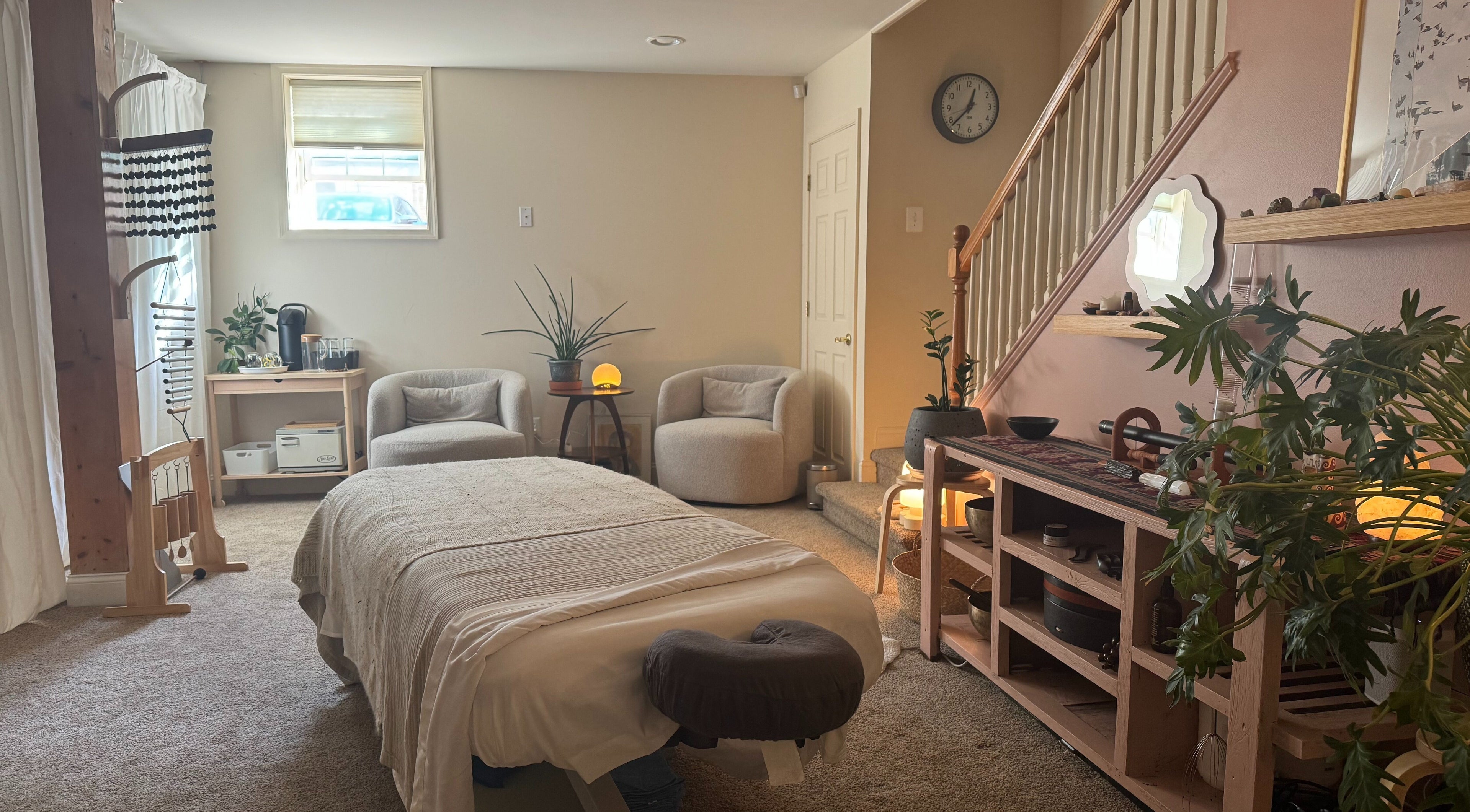 Serene wellness room at Gaia Space, Philadelphia, Pennsylvania, US with massage bed and cozy chairs.