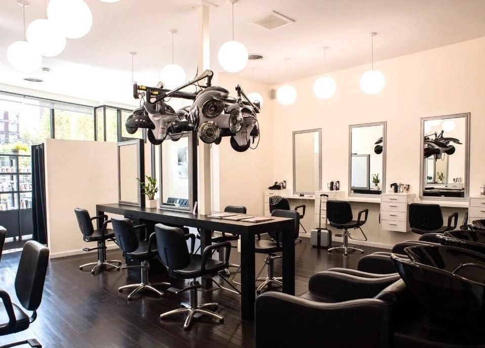 Elegant interior of K&S Salon, Albany, New York, US, showcasing modern styling stations and sleek black chairs.