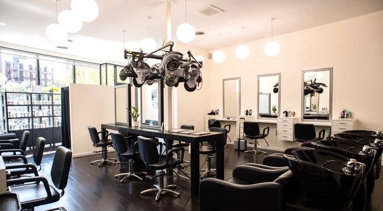 Elegant interior of K&S Salon, Albany, New York, US, showcasing modern styling stations and sleek black chairs.