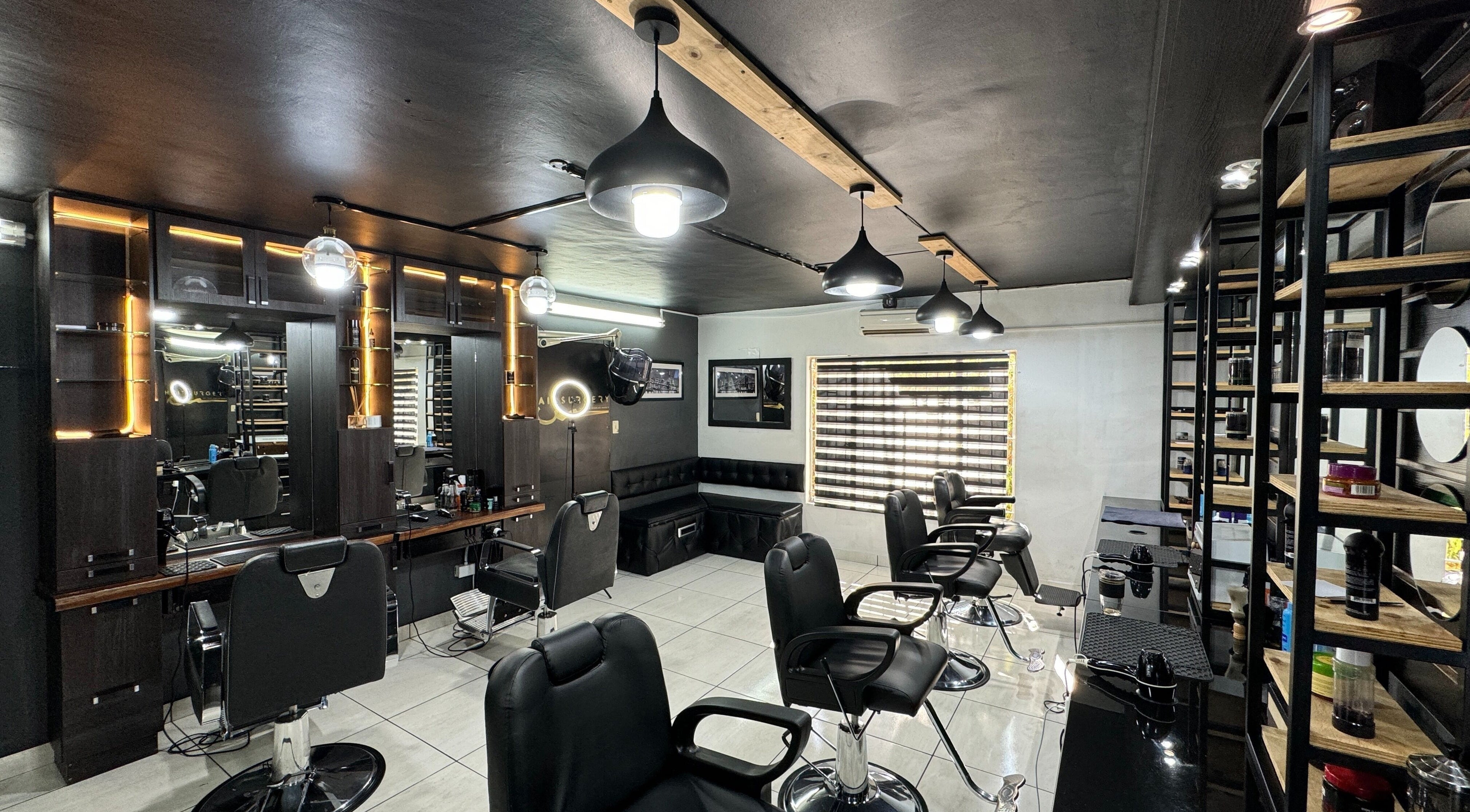 Sleek salon interior at Hairsurgery Lifestyle, Bloemfontein, Free State, ZA with black chairs and modern lighting.