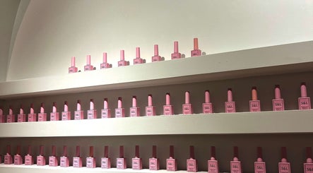 Neatly arranged pink nail polish bottles on shelves at Siara Nails, Paramaribo, Paramaribo, SR.