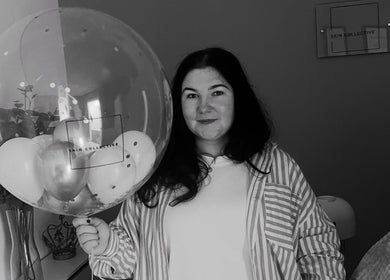 Woman smiling with a Skin Collective branded balloon at Skin Collective, Mossley, England, GB.