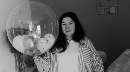 Woman smiling with a Skin Collective branded balloon at Skin Collective, Mossley, England, GB.