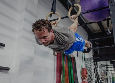Man performing gymnastic rings exercise at Resalve LTD, Coventry, England, GB gym facility.