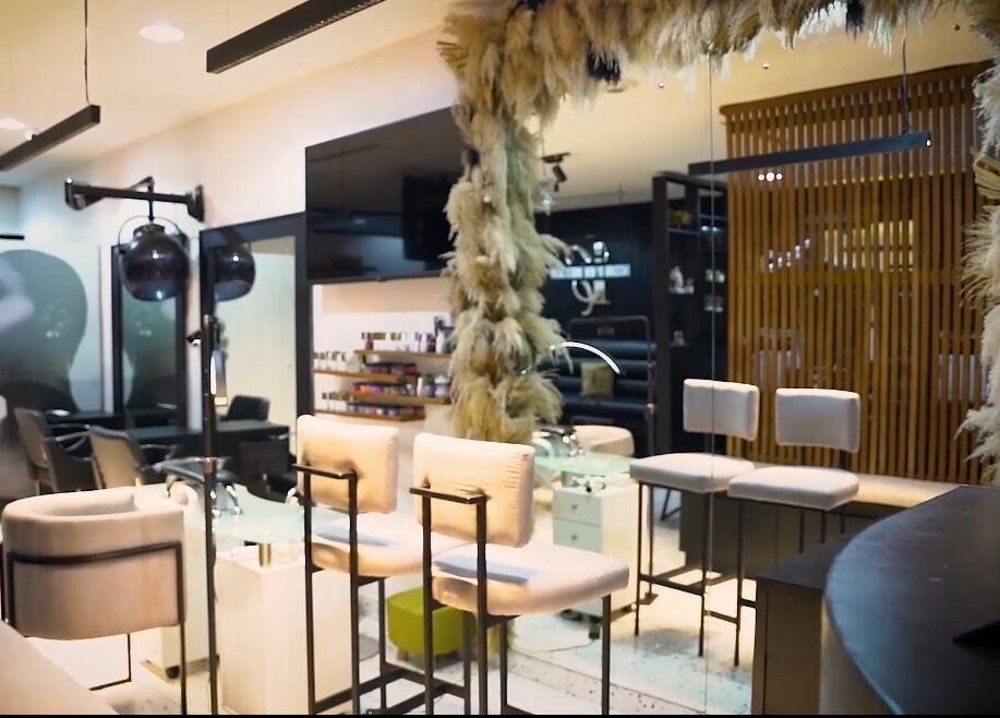 Interior view of Mufasxclusivetouch salon, Abuja, showcasing elegant seating and decor.