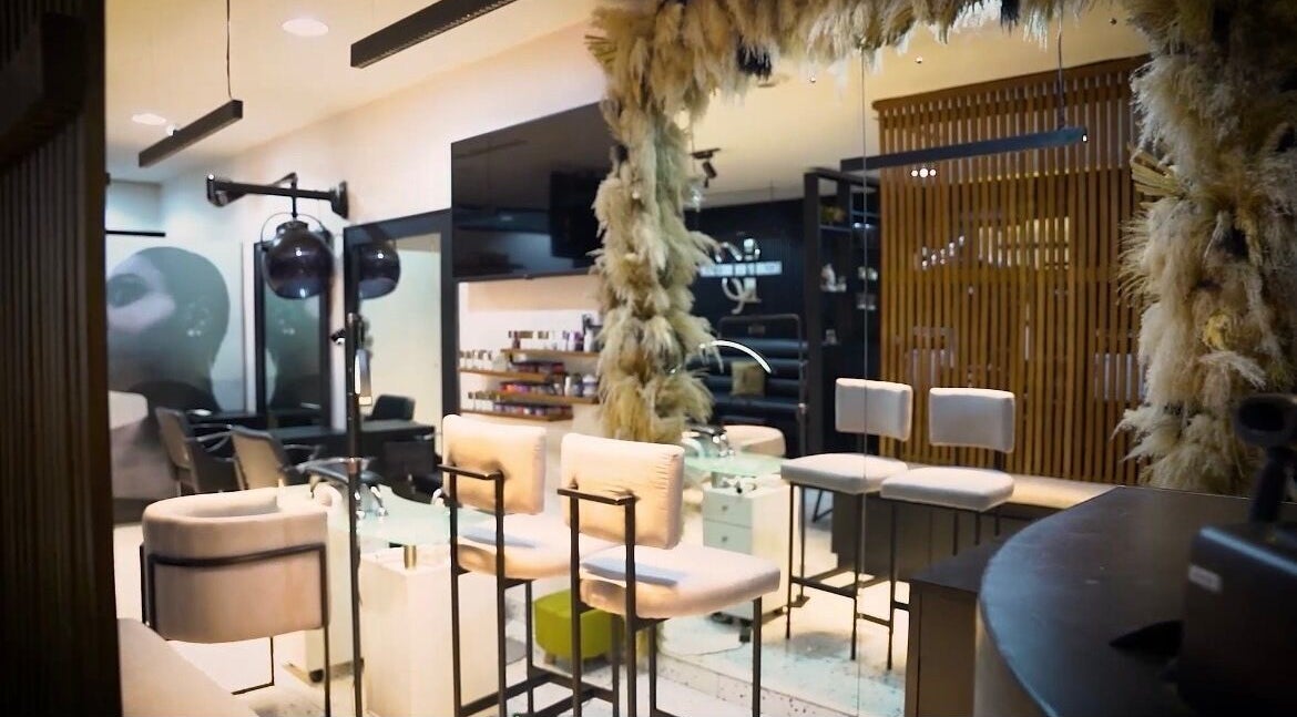 Interior view of Mufasxclusivetouch salon, Abuja, showcasing elegant seating and decor.