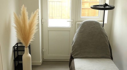 Tranquil treatment room at WZAesthetics London, England, GB. Cozy chair and elegant pampas decor.