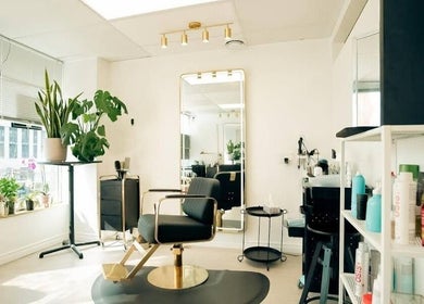 Modern salon chair and mirror at Y's Hair Lab, Toronto, Ontario, CA, with plants and products.