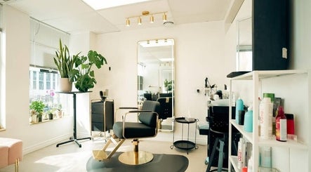 Modern salon chair and mirror at Y's Hair Lab, Toronto, Ontario, CA, with plants and products.