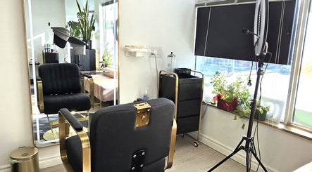 Stylish interior of Y's Hair Lab in Toronto, Ontario, CA featuring a chic black and gold salon chair by a large mirror.