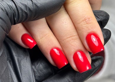 Vibrant red manicure done at Karas Beauty Hub in Montreal, Canada, CA. Perfectly polished nails.