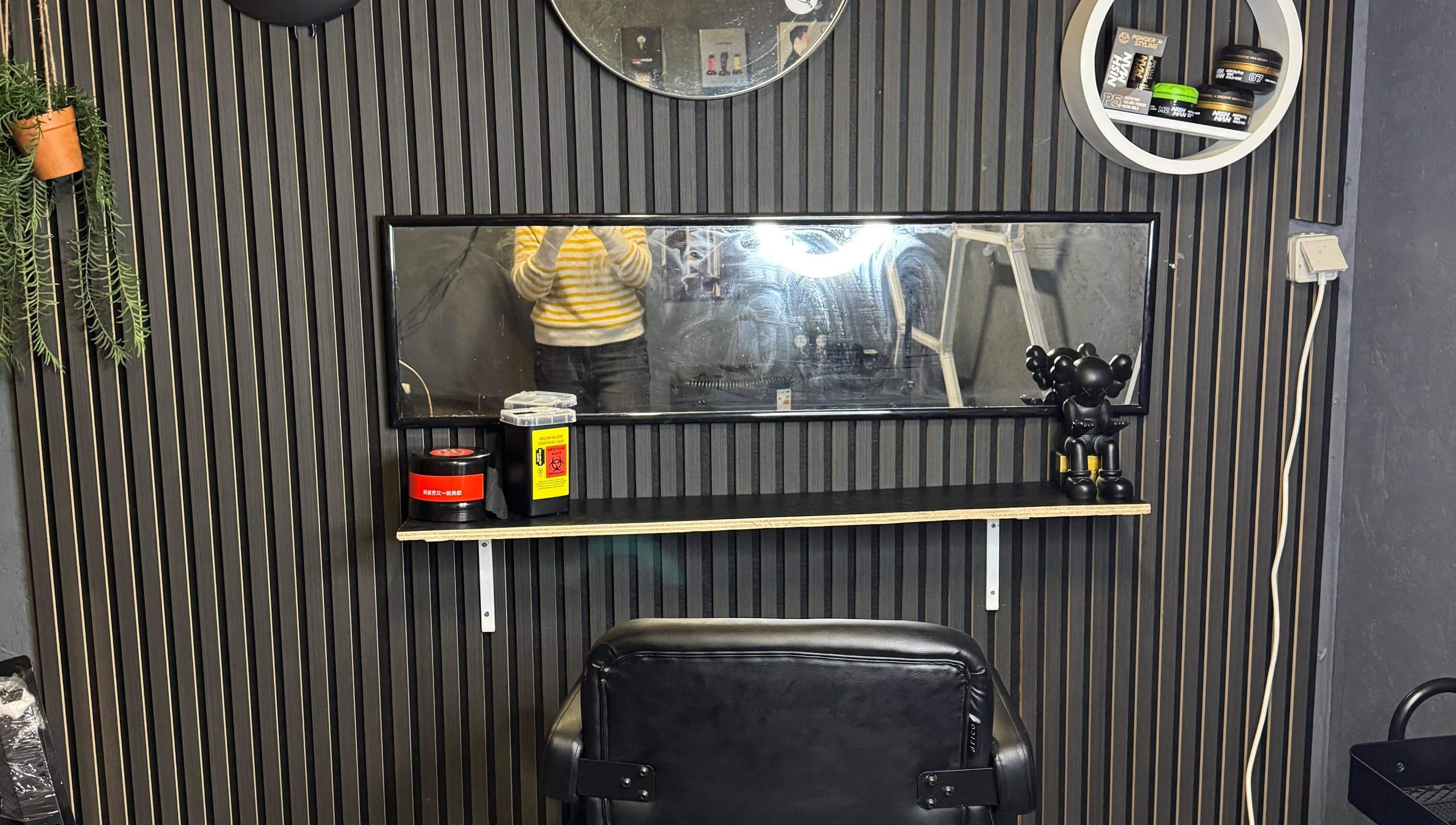 Moderne salonindretning hos Sb Cutzz, Brøndby Strand, DK med sort stol og spejl væg.