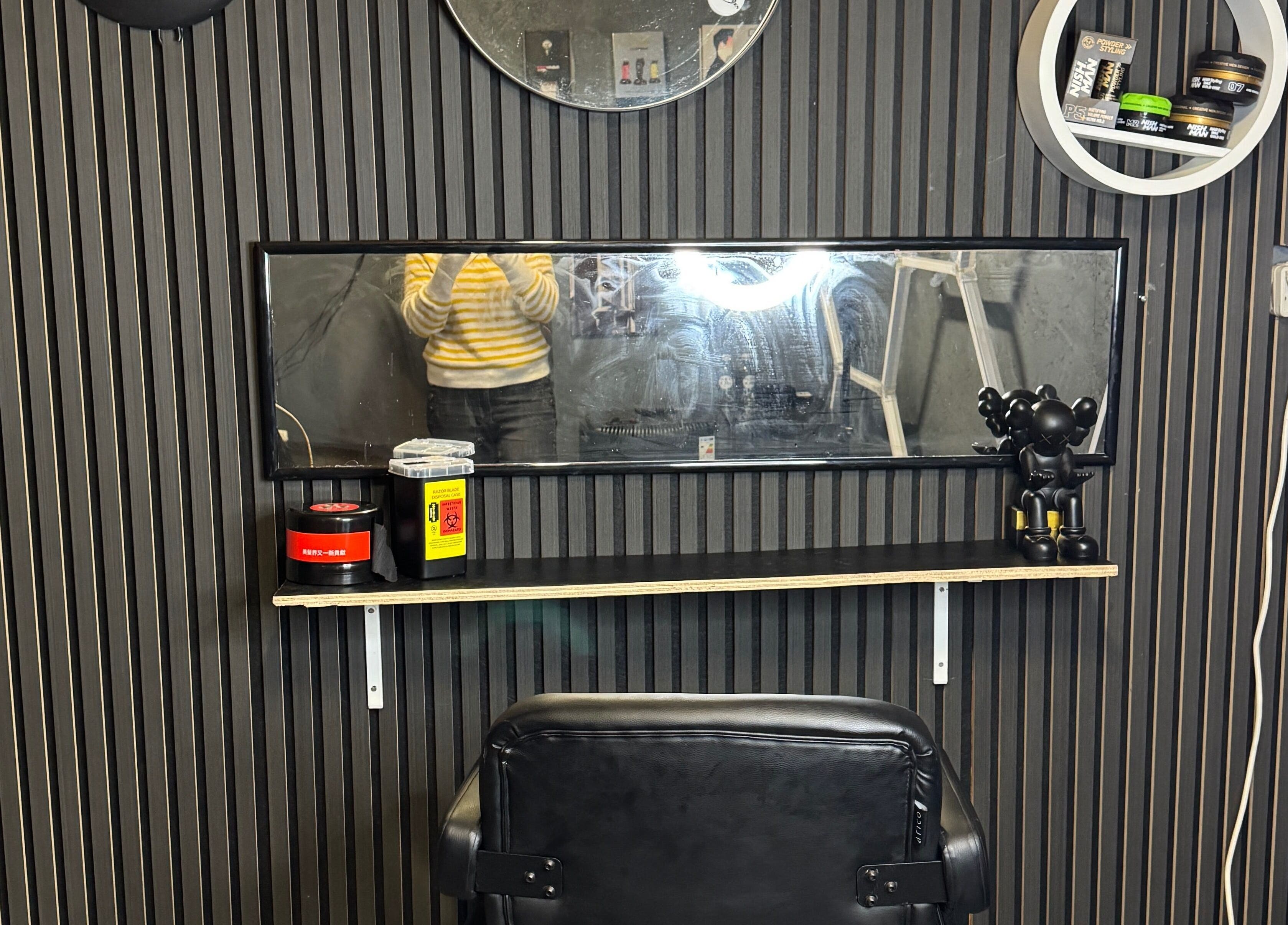 Moderne salonindretning hos Sb Cutzz, Brøndby Strand, DK med sort stol og spejl væg.