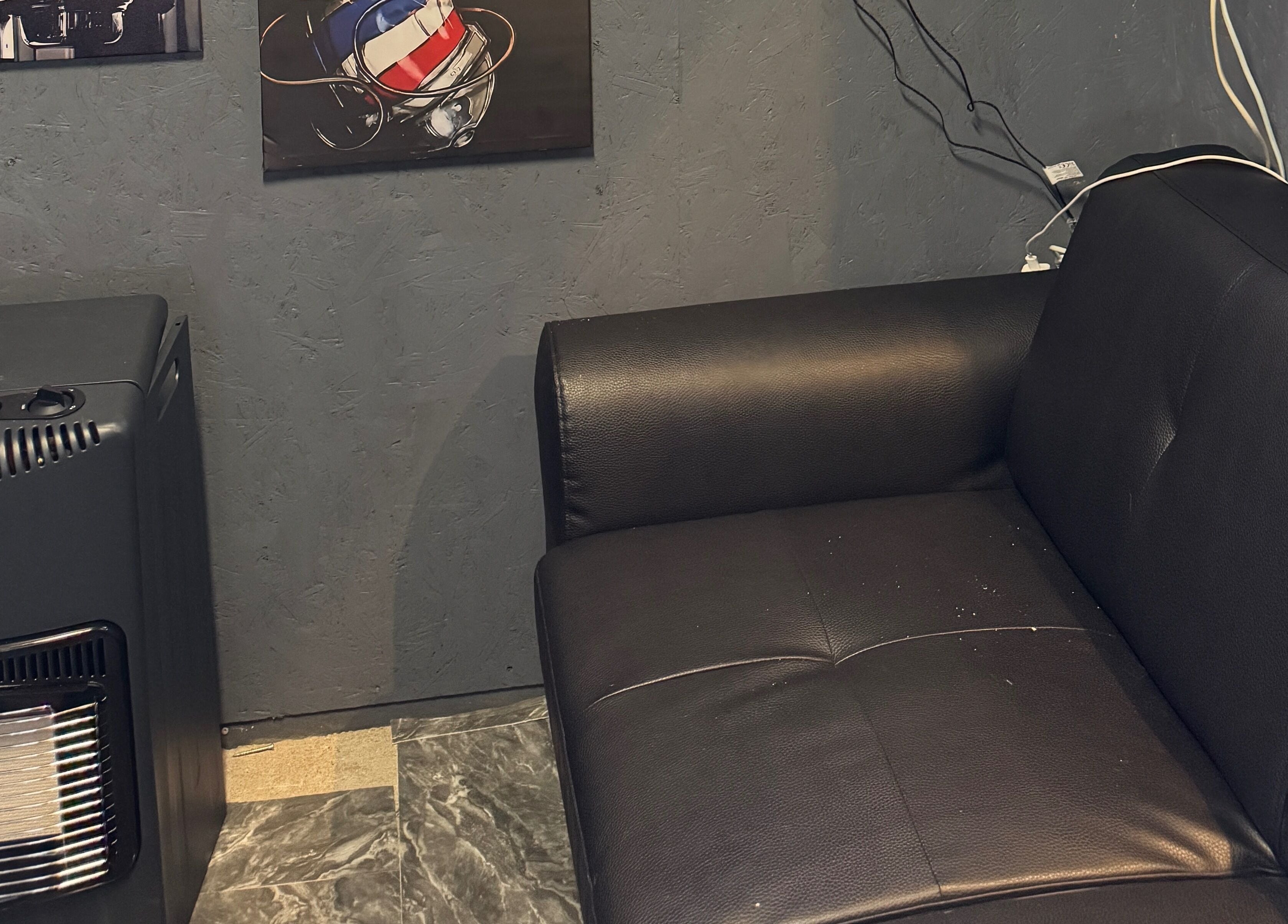 Moderne sort sofa ved Sb Cutzz, Brøndby Strand, DK, med trendy vægdekoration.