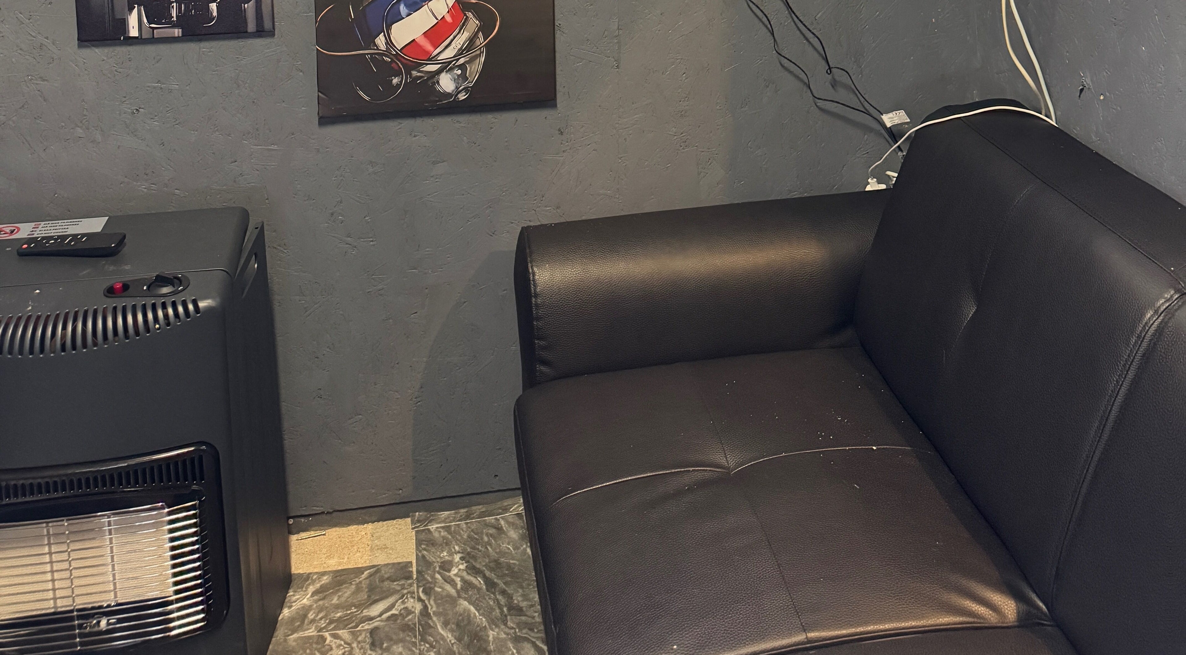 Moderne sort sofa ved Sb Cutzz, Brøndby Strand, DK, med trendy vægdekoration.