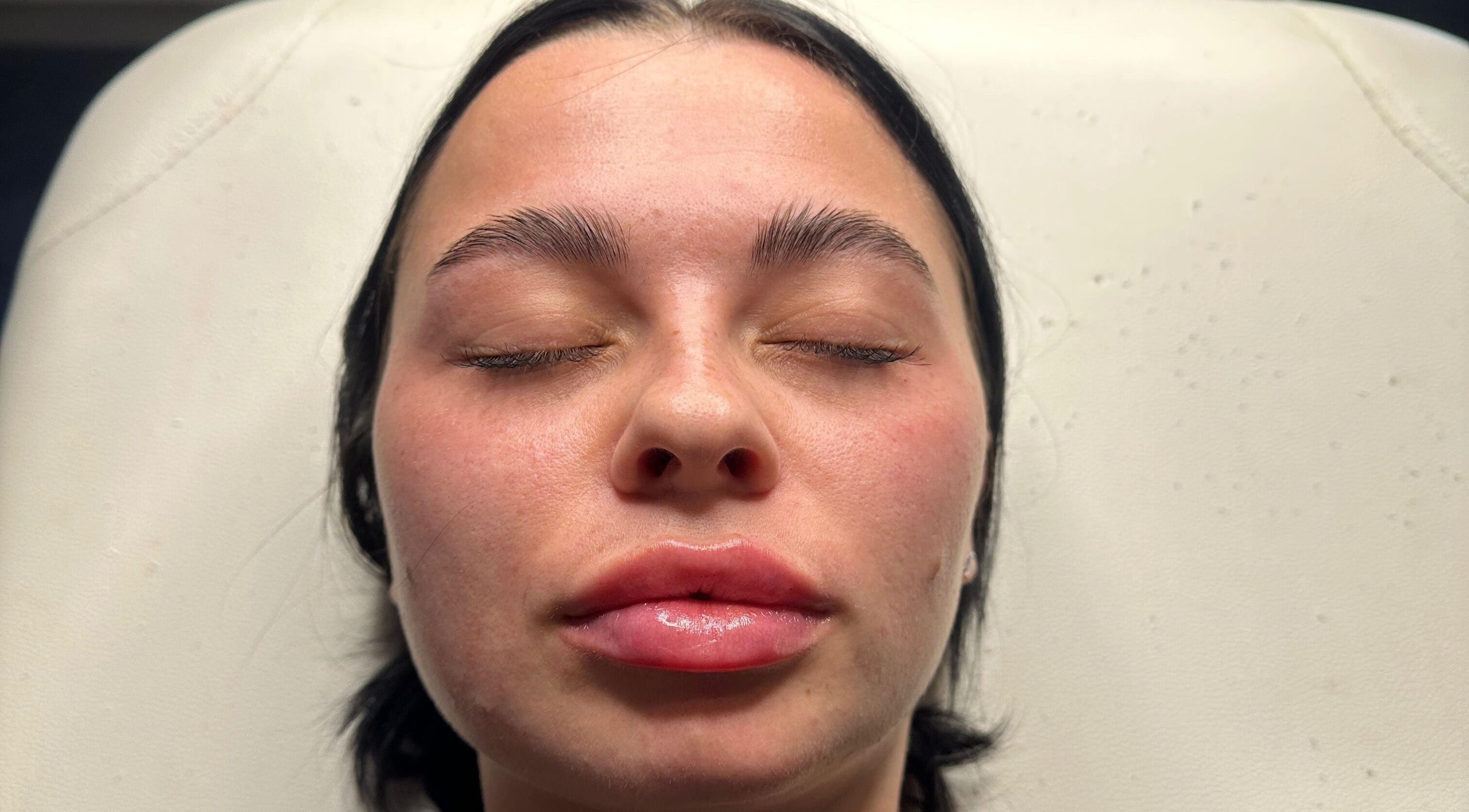 Relaxed woman enjoying a facial at Revive Aesthetics Herts in Watford, England, GB.